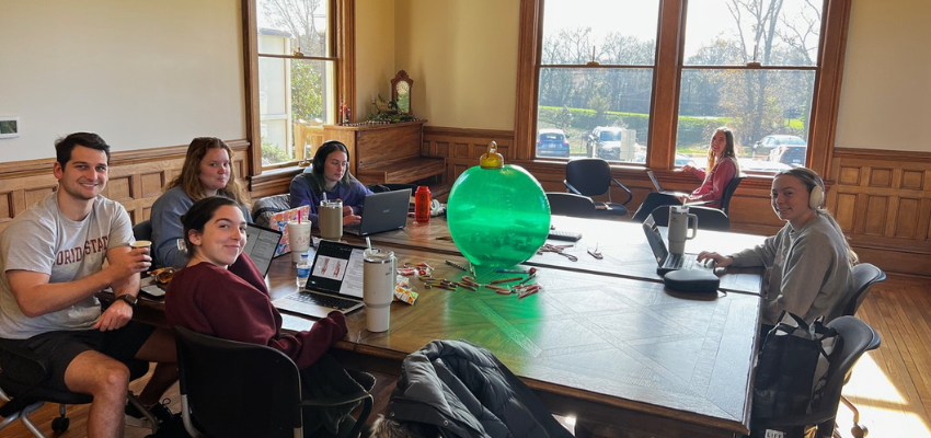Students studying in a wood-paneled room in historic DuPre house