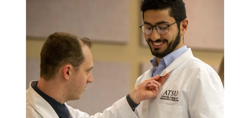 Student receives a lapel pin