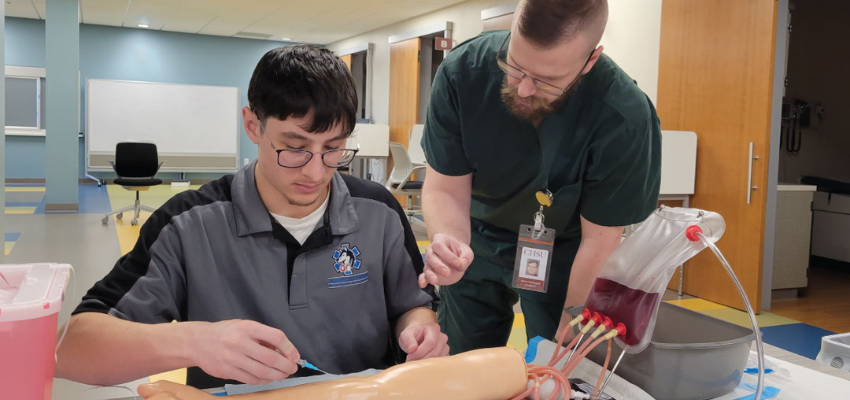 Student tries to find IV on mannequin's arm