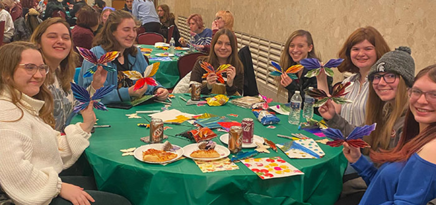 Students hold up colorful butterflies