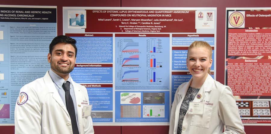 Male and female med students display their research poster