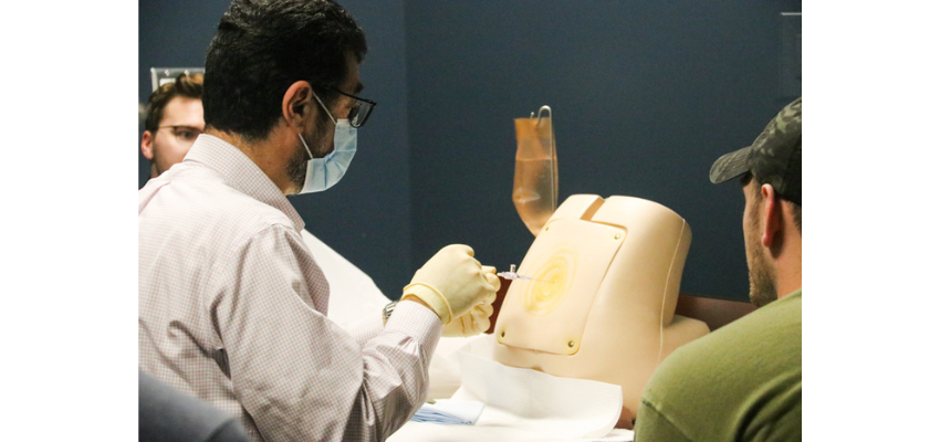 Medical student practices lumbar puncture on manikin