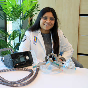 Neeti sitting behind a CPAP machine