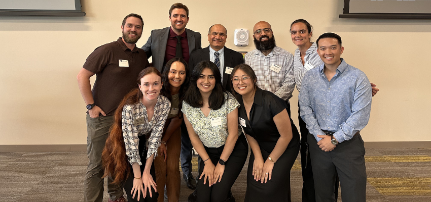 A group of attendees smiling and posing for a photo at a professional event or conference.