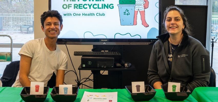 Two students sit at a table with a recycling activity, showcasing the