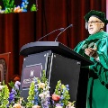AspeakeringreenacademicregaliadeliversremarksatapodiumduringaNoordaCollegeofOsteopathicMedicineceremony