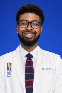 Professional headshot of a student physician wearing a white coat, glasses, and striped tie against a blue background.