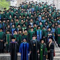 Graduatingosteopathicmedicalstudentsandfacultyposeforaclassphotoonoutdoorstepsinfrontofanurbancampusbuilding