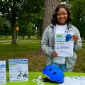 Acommunityhealtheducatordisplayse-bikesafetyandhelmetinformationduringanoutdoorpublicsafetyevent