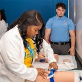 Astudentpracticesaclinicalprocedureonasimulationmodelduringahands-onskillstrainingsessionwhileaninstructorobserves