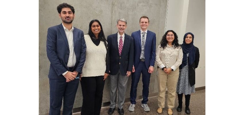 Medical students and a faculty member pose together following a meeting or academic event.