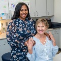 Aphysicianstandsbesideasmilingpatientinanexaminationroomduringaclinicalvisit