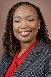 Portrait of a PCOM South Georgia faculty member wearing a gray blazer and red blouse.