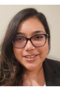 Portrait of a smiling PCOM Georgia student wearing glasses and a dark blazer.
