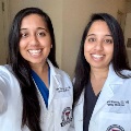 Twophysiciansinwhitecoatssmileforaselfiewhilewearingmedicalscrubs
