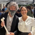 Twopeopleincostumeposetogetheratanoutdooreventwithoneholdingananatomicalmodelofalegbone