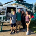 FourpeopleposeinfrontofanAcadianAirMedmedicalhelicopteroutdoors
