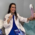Amedicalstudentinawhitecoatrecordsherselfonheriphone