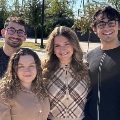 Foursmilingmedicalstudentsposetogetheroutdoorsonasunnyday