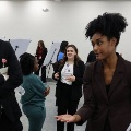 Awomandiscussesaresearchposterwithamanduringanacademicposterpresentationevent
