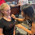 Awomandemonstratesamedicalprocedureonanotherwomansupperchestduringahands-oneducationalsession