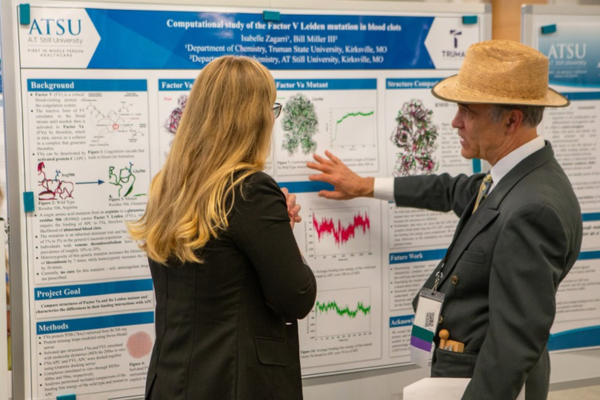 r. Degenhardt at the annual Interdisciplinary Biomedical Research Symposium held on ATSU-COM’s Kirksville campus looking at a poster alongside a woman