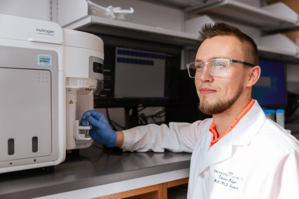 : Tanner Wetzel working a flow cytometer to categorize different cells