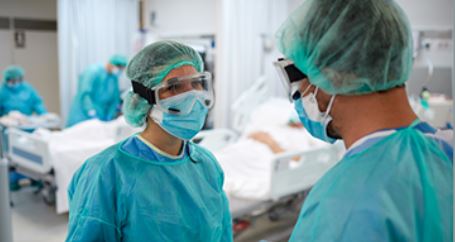 Doctors in surgical garb discussing a case