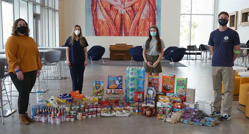 ICOM's Pediatrics Club students pose in front of collected food items.