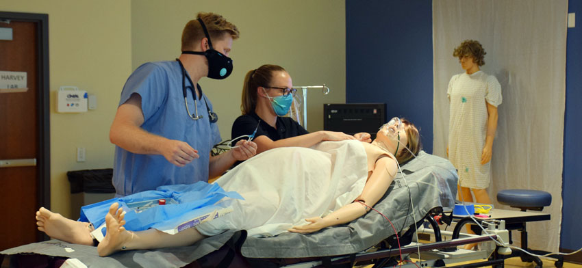 RVUCOM students practicing healthcare on a simulated patient.