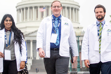 Osteopathic med students in white coats at the U.S. Capitol. 