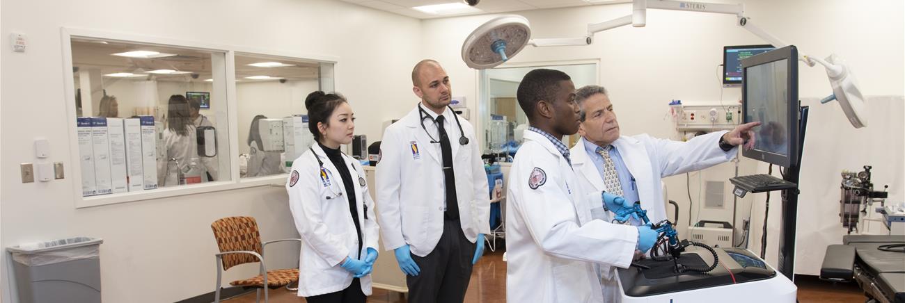 Med students learn to use a simulator.