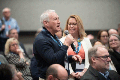 Man answering question in the audience during Educating Leaders
