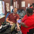 Studentsmileswhileseatedandgettinghisblooddrawn