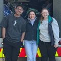 Threestudentsstandinfrontofanambulance