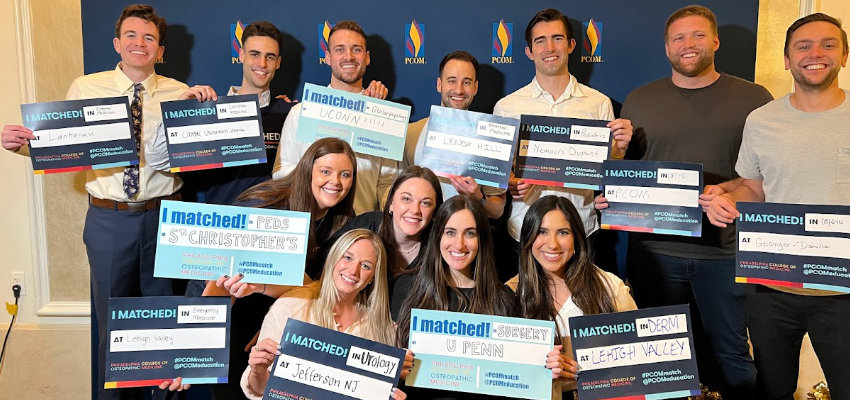 PCOM students holding posters of the residencies they matched to.