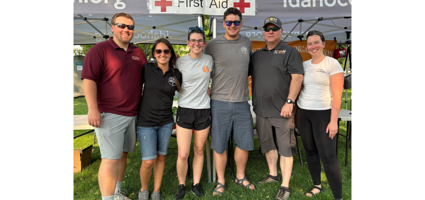 A team of volunteers standing in front of a first aid tent at an outdoor event.