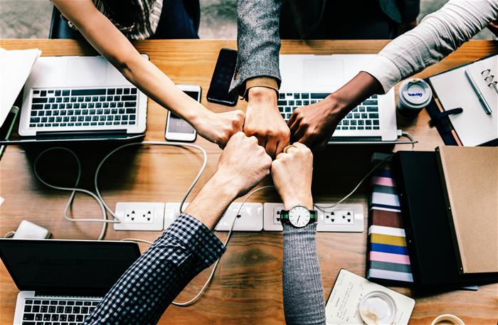 workplace colleagues fist bumping