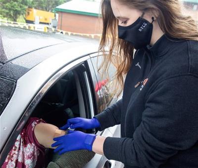 Kentucy College of Optometry student at the university of Pikeville gives a COVID-19 vaccination in April 2021.